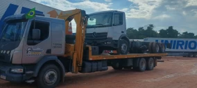 Guincho tipo plataforma transportando um caminhão Mercedes-Benz em Belém, com céu nublado ao fundo.