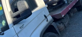 Guincho plataforma estacionado com um veículo preto sobre ele, em Conceição do Jacuípe.