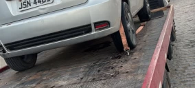 Veículo prateado estacionado em guincho de plataforma, com as rodas traseiras suspensas, em Conceição do Jacuípe.