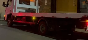 Guincho plataforma estacionado em Assis, com iluminação traseira visível.