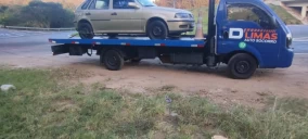 Guincho plataforma em Campinas transportando um veículo sedan dourado.