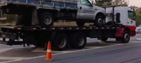 Guincho plataforma transportando uma caminhonete de cor prata em São Bernardo do Campo, estacionado na via.