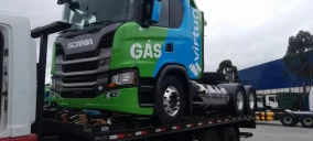 Guincho plataforma transportando caminhão Scania verde e azul, com a palavra "GÁS", em São Bernardo do Campo.
