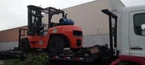Guincho plataforma transportando empilhadeira laranja em São Bernardo do Campo.