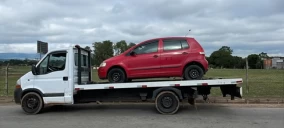 Guincho plataforma branco transportando um carro vermelho, estacionado em Jundiaí.