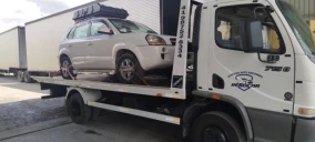 Guincho plataforma em São José dos Pinhais transportando um veículo SUV branco.