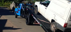 Guincho plataforma azul transportando uma caminhonete branca em São Roque, com o veículo parcialmente içado.