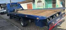 Guincho plataforma azul estacionado em rua de Sapeaçu, sem veículo transportado visível.